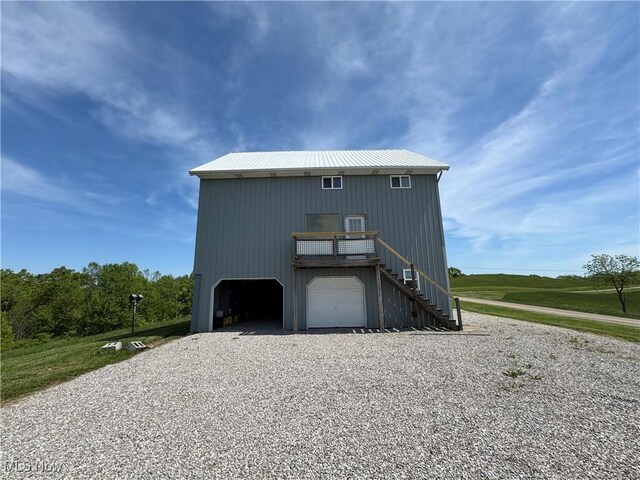 6255 Highland Ridge Rd, Lowell, OH 45744 - view of front facade with stairs, driveway, metal roof, and a garage