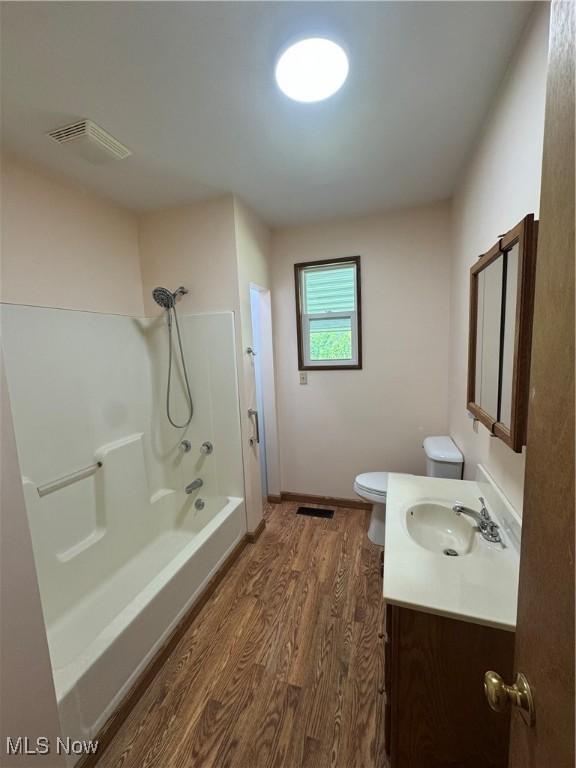 6255 Highland Ridge Rd, Lowell, OH 45744 - full bathroom featuring wood finished floors, toilet, vanity, bathtub / shower combination, and baseboards