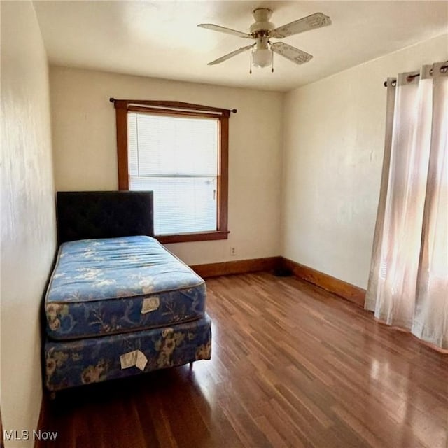 bedroom with wood finished floors, baseboards, and ceiling fan