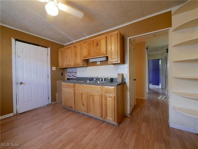 111 Pine Ln, Barnesville, OH 43713 - kitchen featuring crown molding, dark countertops, light wood-style floors, a sink, and backsplash