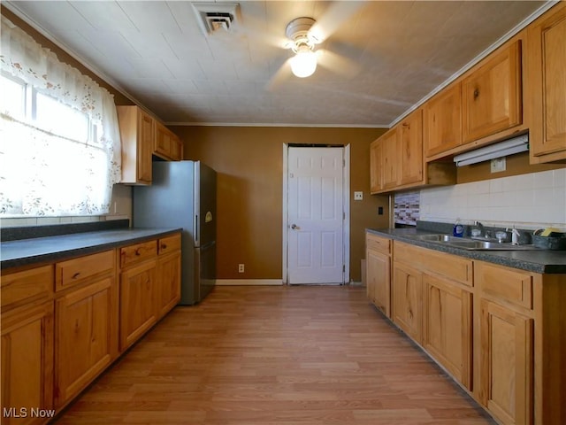 111 Pine Ln, Barnesville, OH 43713 - kitchen featuring a sink, dark countertops, light wood-style flooring, tasteful backsplash, and ornamental molding