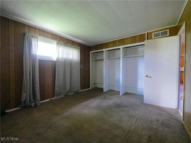 111 Pine Ln, Barnesville, OH 43713 - unfurnished bedroom featuring wood walls, carpet, and a closet