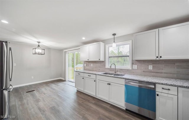 1527 Carterland Dr, Ashtabula, OH 44004 - kitchen with dishwashing machine, a sink, freestanding refrigerator, backsplash, and white cabinetry