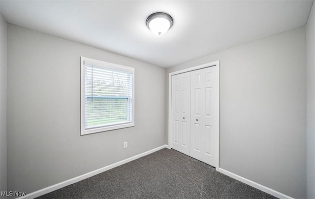 1527 Carterland Dr, Ashtabula, OH 44004 - unfurnished bedroom with a closet, baseboards, and dark carpet