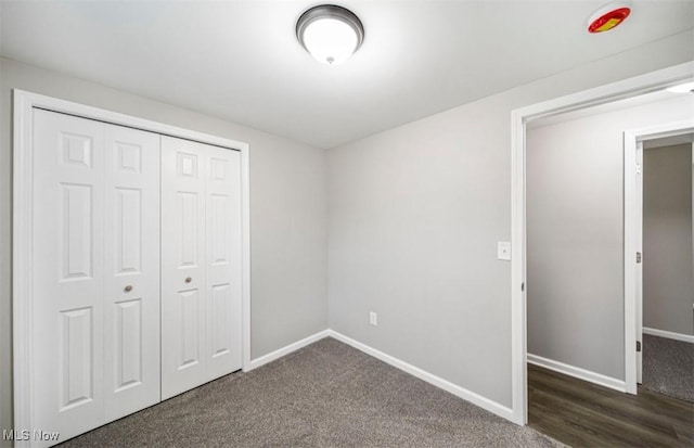 1527 Carterland Dr, Ashtabula, OH 44004 - unfurnished bedroom with baseboards, a closet, and dark carpet