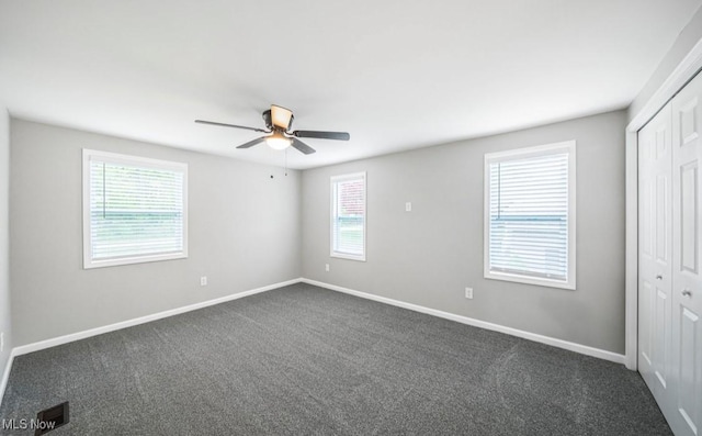 1527 Carterland Dr, Ashtabula, OH 44004 - unfurnished bedroom featuring a closet, multiple windows, and dark carpet