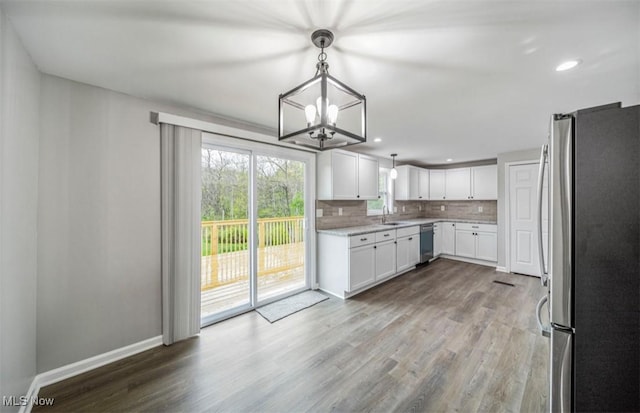 1527 Carterland Dr, Ashtabula, OH 44004 - kitchen with appliances with stainless steel finishes, a sink, wood finished floors, a chandelier, and backsplash