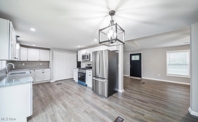 1527 Carterland Dr, Ashtabula, OH 44004 - kitchen featuring appliances with stainless steel finishes, a sink, baseboards, decorative backsplash, and recessed lighting