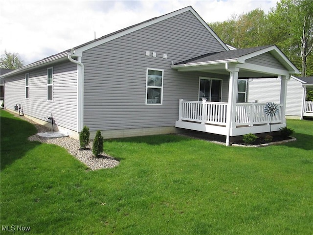 rear view of house featuring a lawn and a deck