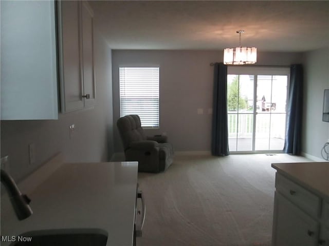 dining space with carpet flooring, a chandelier, and baseboards