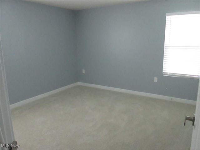 empty room with light colored carpet and baseboards