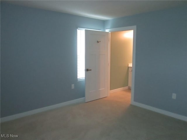 carpeted empty room with baseboards