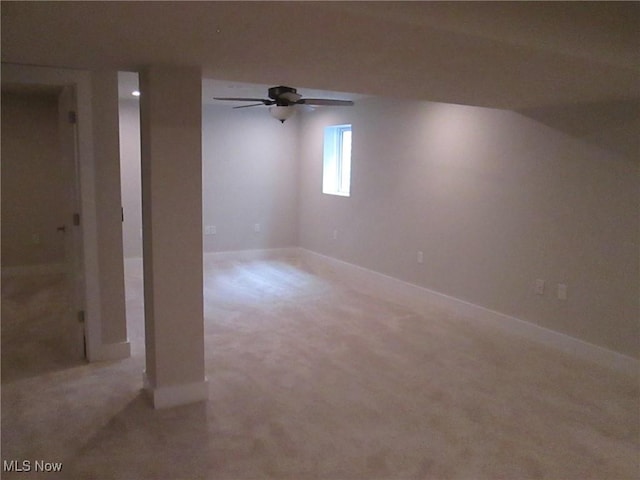 carpeted empty room featuring a ceiling fan and baseboards