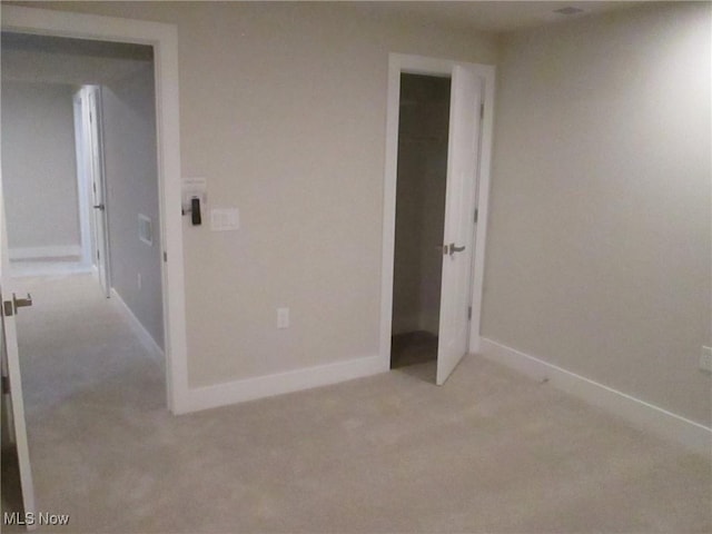 unfurnished bedroom featuring light carpet and baseboards