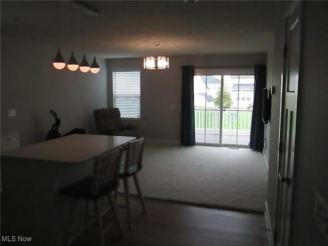 dining room featuring carpet, a chandelier, and baseboards