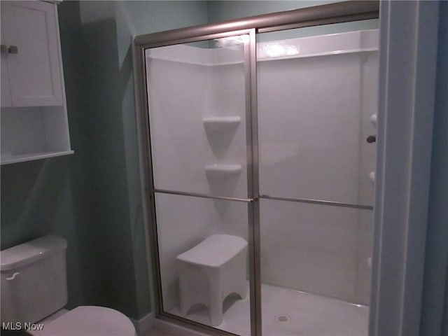 full bath with toilet and a stall shower