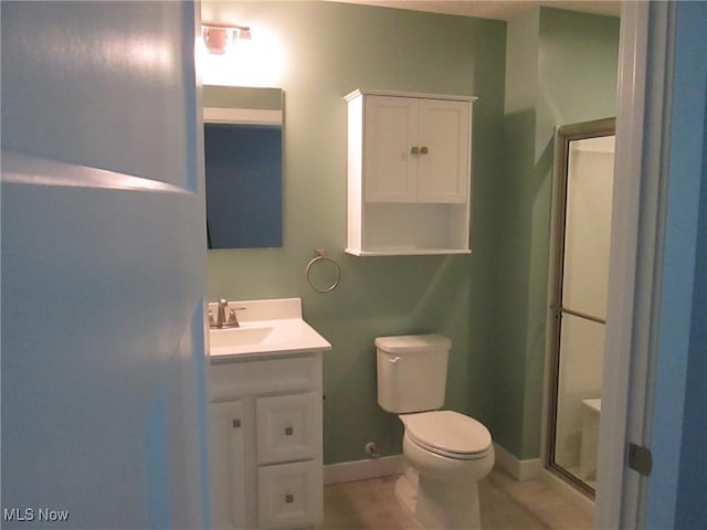 full bath with a shower stall, toilet, vanity, and baseboards
