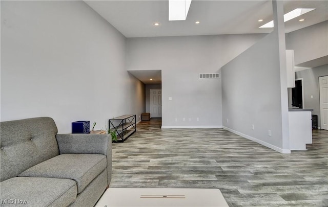 213 Knollton Dr, Millersburg, OH 44654 - living room featuring a skylight, wood finished floors, baseboards, recessed lighting, and a towering ceiling