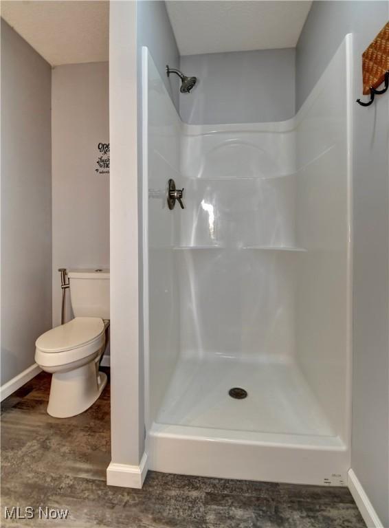 213 Knollton Dr, Millersburg, OH 44654 - full bath featuring a shower stall, toilet, baseboards, and wood finished floors