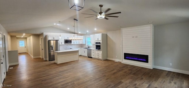 1404 15th St, Vienna, WV 26105 - kitchen featuring appliances with stainless steel finishes, open floor plan, ceiling fan, white cabinetry, and vaulted ceiling