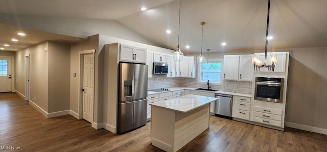 1404 15th St, Vienna, WV 26105 - kitchen featuring stainless steel appliances, backsplash, light countertops, vaulted ceiling, and a kitchen island
