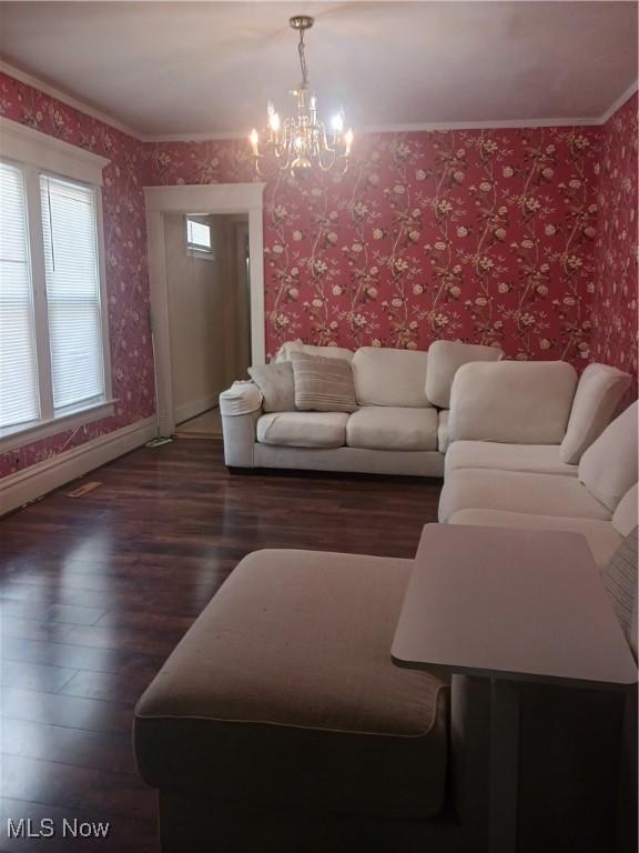 636 4th St, Marietta, OH 45750 - living room featuring wood finished floors, a chandelier, wallpapered walls, baseboards, and crown molding