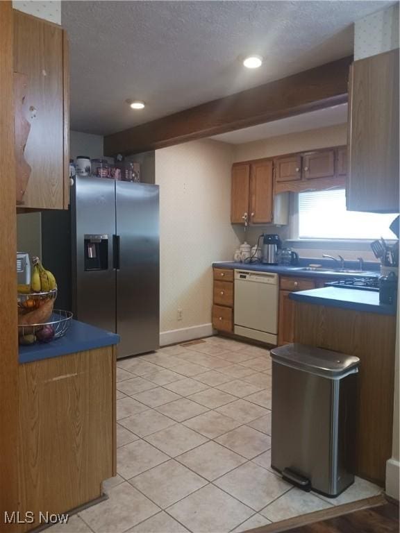 636 4th St, Marietta, OH 45750 - kitchen with white dishwasher, a sink, stainless steel fridge, a textured ceiling, and light tile patterned floors