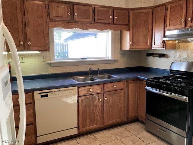 636 4th St, Marietta, OH 45750 - kitchen with stainless steel gas range, white dishwasher, under cabinet range hood, a sink, and dark countertops