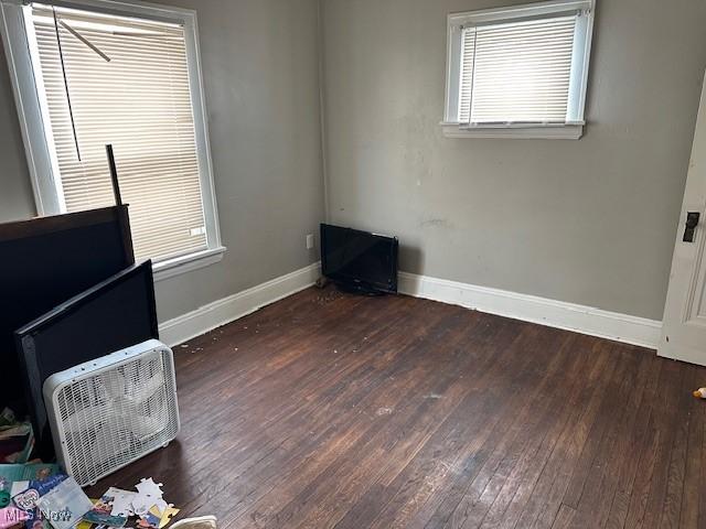 unfurnished bedroom featuring hardwood / wood-style flooring and baseboards