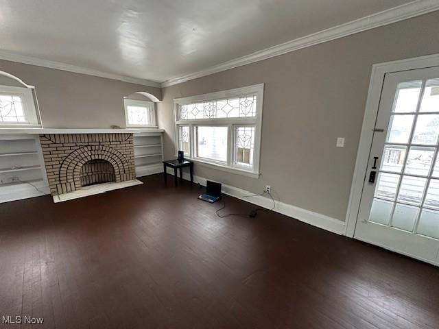 unfurnished living room featuring wood finished floors, a fireplace, ornamental molding, and healthy amount of natural light