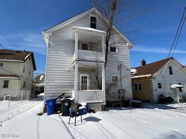 view of snow covered back of property