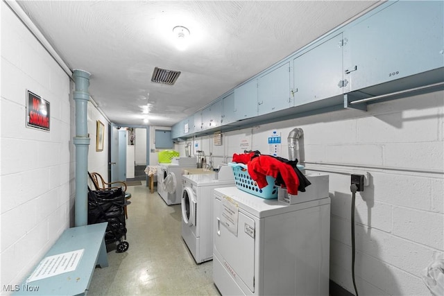 19901 Van Aken Blvd Unit 7, Shaker Heights, OH 44122 - laundry area with washing machine and clothes dryer, cabinet space, and concrete block wall