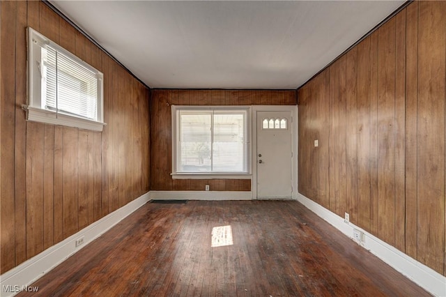 entryway featuring healthy amount of natural light, hardwood / wood-style flooring, baseboards, and wooden walls