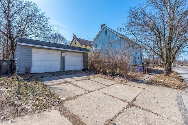 view of property exterior featuring a detached garage and an outdoor structure