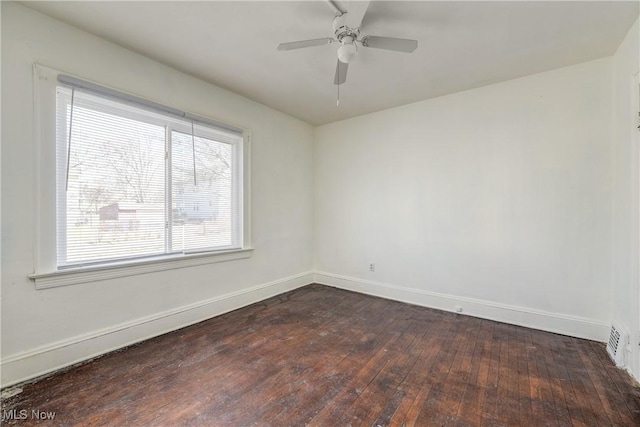 unfurnished room featuring dark wood-type flooring, baseboards, and a ceiling fan