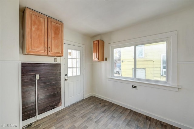 doorway featuring light wood-type flooring, healthy amount of natural light, and baseboards