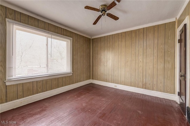 unfurnished room featuring dark wood-type flooring, ceiling fan, and baseboards