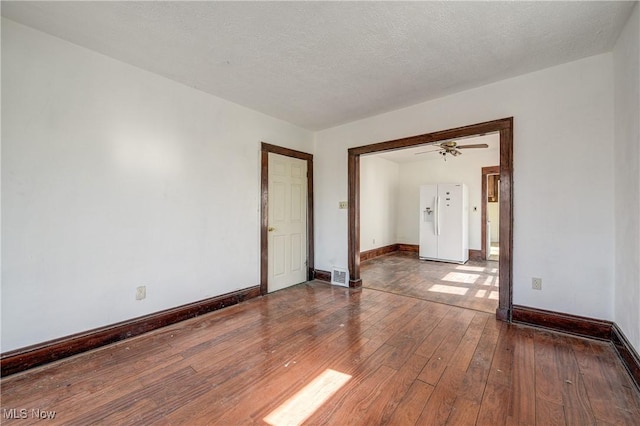 spare room with hardwood / wood-style floors, baseboards, and ceiling fan