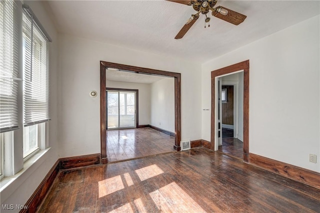 spare room featuring hardwood / wood-style floors, a ceiling fan, and baseboards