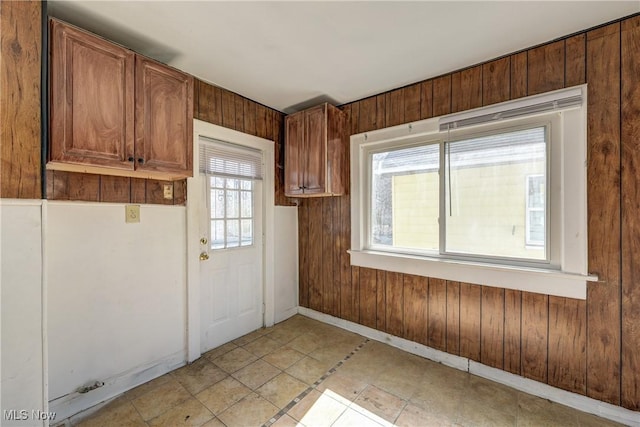 kitchen with wood walls, baseboards, and brown cabinetry