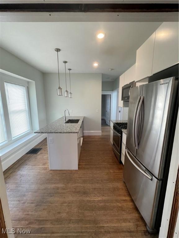 3217 W 14th St, Cleveland, OH 44109 - kitchen with appliances with stainless steel finishes, a sink, baseboards, white cabinetry, and dark wood-style floors