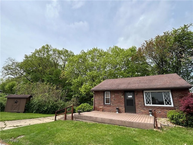 385 Truax Ln, Weirton, WV 26062 - view of front facade featuring brick siding, a wooden deck, a storage unit, a front lawn, and an outbuilding