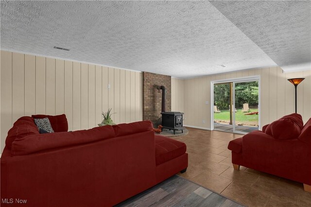 1060 S Watkins Rd, Alexandria, OH 43001 - living room with a wood stove, wood finished floors, a textured ceiling, and wood walls
