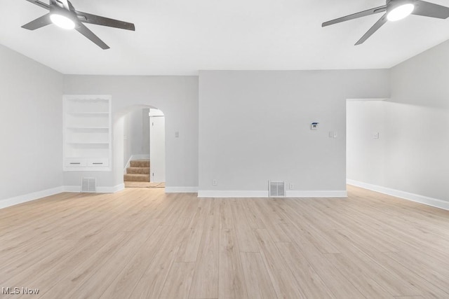 38 W Washington St, Alliance, OH 44601 - unfurnished living room with ceiling fan, arched walkways, light wood-style flooring, baseboards, and vaulted ceiling