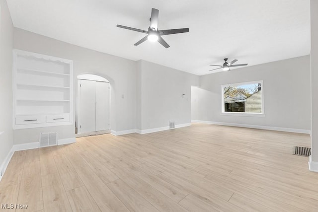 38 W Washington St, Alliance, OH 44601 - unfurnished living room with a ceiling fan, baseboards, arched walkways, light wood-style floors, and built in features