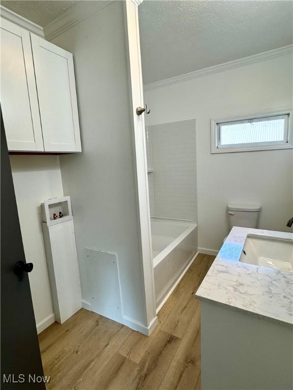 1226 E Main St, Coshocton, OH 43812 - bathroom with crown molding, wood finished floors, toilet, vanity, and baseboards