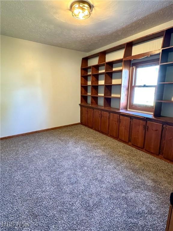1226 E Main St, Coshocton, OH 43812 - carpeted spare room featuring a textured ceiling and baseboards