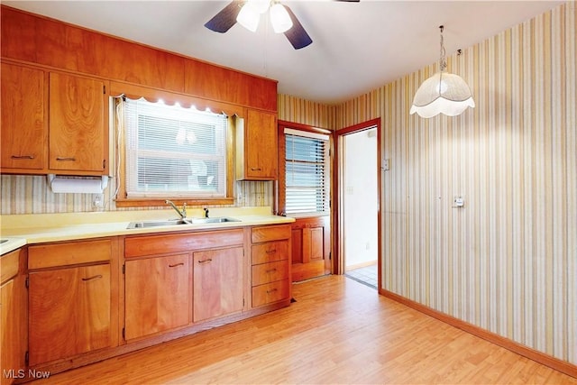 2455 Alexander Mnr E, Steubenville, OH 43952 - kitchen featuring wallpapered walls, a sink, light wood-style floors, light countertops, and ceiling fan