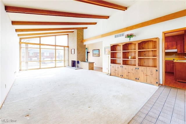 2455 Alexander Mnr E, Steubenville, OH 43952 - unfurnished living room featuring beam ceiling, light tile patterned flooring, light colored carpet, and high vaulted ceiling