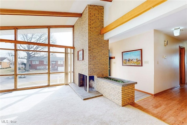 2455 Alexander Mnr E, Steubenville, OH 43952 - living area featuring a fireplace, beamed ceiling, high vaulted ceiling, expansive windows, and light colored carpet